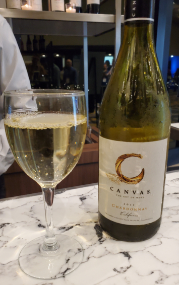 a glass and bottle of canvas chardonnay